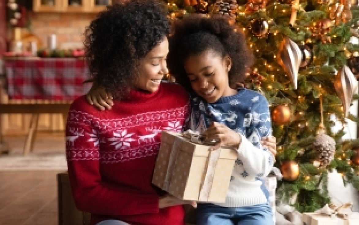 Photo of a mother and daughter opening a present